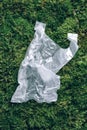 Disposable plastic bag on green moss, grass background. Pollution problem concept. Top view. Copy space. Environmental Royalty Free Stock Photo