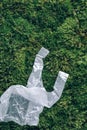 Disposable plastic bag on green moss, grass background. Pollution problem concept. Top view. Copy space. Environmental Royalty Free Stock Photo