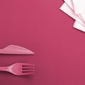 Disposable plastic cutlery. Plastic fork and knife Image toned in Viva Magenta, color of the 2023 year
