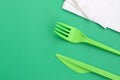 Disposable plastic cutlery green. Plastic fork and knife lie on