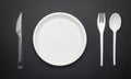 Disposable plastic tableware, fork, knife, spoon and plate on black background Royalty Free Stock Photo