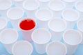 Disposable plastic white empty cups on and one glass filled with red lemonade Royalty Free Stock Photo