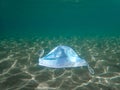 Disposable protection mask under sea, residues of the covid-19 pandemic, overuse of surgical masks during coronavirus pandemic Royalty Free Stock Photo