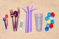 Disposable single use plastic objects that cause pollution of the environment, especially oceans. Top view on sand Royalty Free Stock Photo