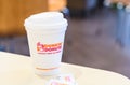 Dunkin donuts cup of hot coffee and sugar sachet on table Royalty Free Stock Photo