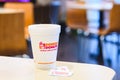 Dunkin donuts cup of hot coffee and sugar sachet on table Royalty Free Stock Photo