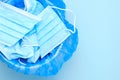 Disposable surgical mask is thrown to the trash bin on a blue background with copy space. Coronavirus and quarantine is over. End Royalty Free Stock Photo