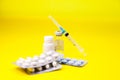 Disposable syringe , tablets and medicine on yellow background Royalty Free Stock Photo