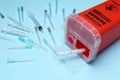 Disposable syringes, needles and sharps container on light blue background