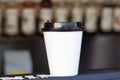 Disposable white coffee mug on table in a coffee shop