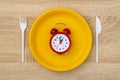 Disposable yellow plate with alarm clock