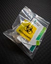 Disposal of Covid 19 saliva test kit in a plastic bag after use. Biohazard specimen bag