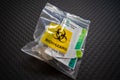 Disposal of Covid 19 saliva test kit in a plastic bag after use. Biohazard specimen bag