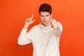 Disrespectful rude young man in white casual sweatshirt showing loser gesture and pointing on you, abuser Royalty Free Stock Photo