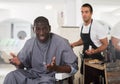 Dissatisfied African male client in hair salon