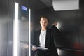 Dissatisfied businesswoman is throwing the papers in the elevator. Discontent office worker is reading and throwing the documents