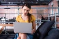 Dissatisfied businesswoman using laptop while sitting