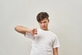 Dissatisfied european teenage boy show thumb down