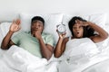 Dissatisfied funny shocked young african american couple wake up from alarm clock