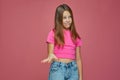 Dissatisfied grimacing cute child girl showing so so gesture on pink studio background. Questionable choice. Bad options Royalty Free Stock Photo