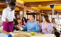 Dissatisfied guests conflicting with african american waiter in restaurant