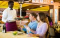 Dissatisfied guests conflicting with african american waiter in restaurant