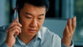 Dissatisfied male businessman client annoyed asian korean angry man talking mobile phone has misunderstanding problem Royalty Free Stock Photo