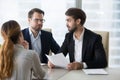 Dissatisfied recruiters exchange skeptic glance disliking female