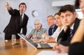 Dissatisfied manager reprimanding subordinates during work meeting