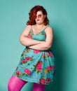 Not happy plus-size overweight lady in sunglasses and sundress with her arms crossed waits for something