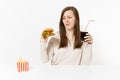 Dissatisfied woman sitting at table with burger, french fries, cola in glass bottle isolated on white background. Proper Royalty Free Stock Photo