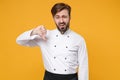 Dissatisfied young bearded male chef cook or baker man in white uniform shirt posing isolated on yellow wall background