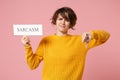 Dissatisfied young brunette woman girl in yellow sweater posing isolated on pastel pink background. People lifestyle Royalty Free Stock Photo