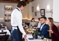 Dissatisfied young couple talking to apologetic waiter Royalty Free Stock Photo