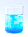 Dissolution process blue chemicals in water in beaker