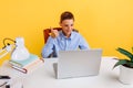 Distance education for children. schoolboy sitting at a table, learning by video link, happy and showing a thumbs up on a yellow