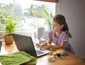 Distance education concept. Covid lockdown. Caucasian preteen girl learns to sew online during self-isolation