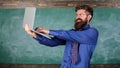 Distance education concept. Teacher bearded man with modern laptop passed test online chalkboard background. Hipster Royalty Free Stock Photo