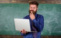 Distance education concept. Teacher bearded man with modern laptop surfing internet chalkboard background. Surfing