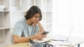 Distance education concept, Teen boy using phone to check class schedule of online learning at home Royalty Free Stock Photo