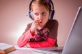 Distance education. Humorous portrait of beautiful young girl learning remotely with headphones and laptop. Horizontal image Royalty Free Stock Photo