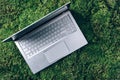 Distance job, freelance work. Remote, home office with laptop on green grass, moss forest background. Ecology travel Royalty Free Stock Photo