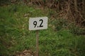 Distance kilometer sign in white with black along rail for train drivers. Royalty Free Stock Photo