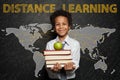 Distance learning and back to school concept. Smiling black child boy against World map on blackboard background Royalty Free Stock Photo