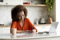 Distance Learning. Black Woman Study With Laptop In Kitchen And Taking Notes Royalty Free Stock Photo