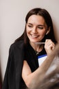 Distance learning. Cheerful girl with book in cafe. Concentrated English teacher writes notes before online lesson via Royalty Free Stock Photo