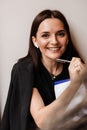 Distance learning. Cheerful girl with book in cafe. Concentrated English teacher writes notes before online lesson via Royalty Free Stock Photo