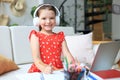 Distance learning. Cheerful little girl using laptop computer studying through online e-learning system Royalty Free Stock Photo