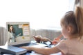 Distance learning. Cheerful little girl using laptop computer studying through online e-learning system