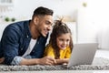 Distance Learning. Cute Little Girl And Arab Dad Using Laptop At Home Royalty Free Stock Photo